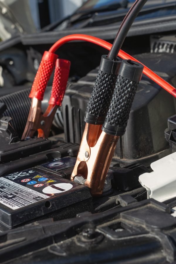 Red and black jumper cable clamps on a battery